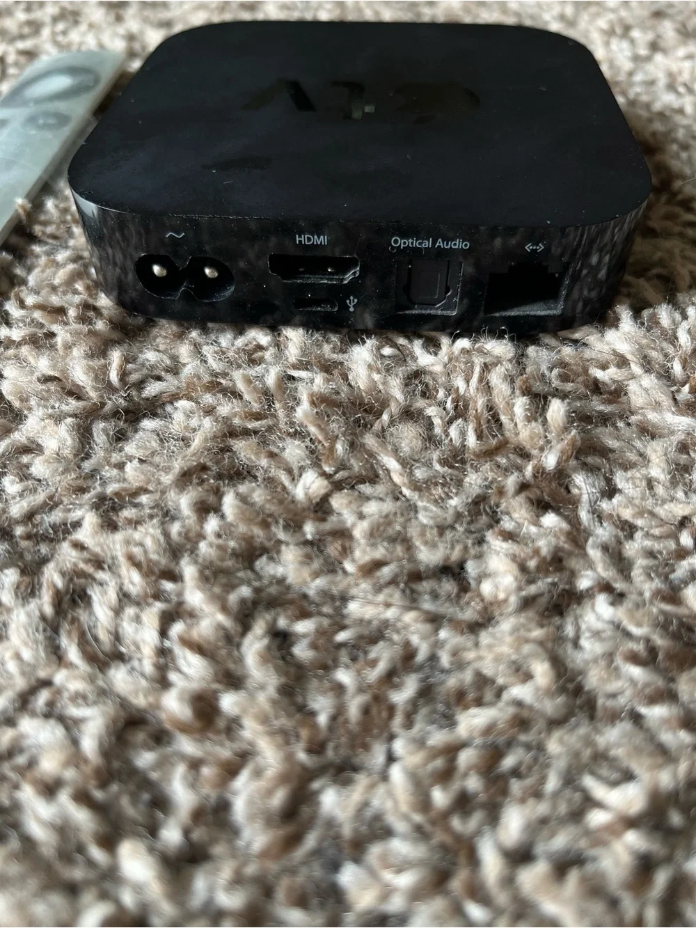 Apple TV with Silver Remote and Black Power Cable